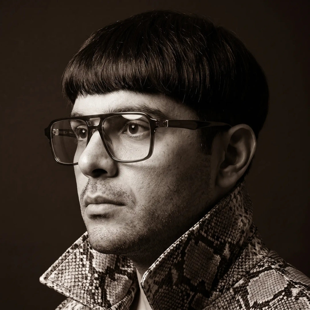 Anteojos Fiore 1039 en azul, en modelo – retrato de campaña, monochrome studio portrait, red graphic accents
