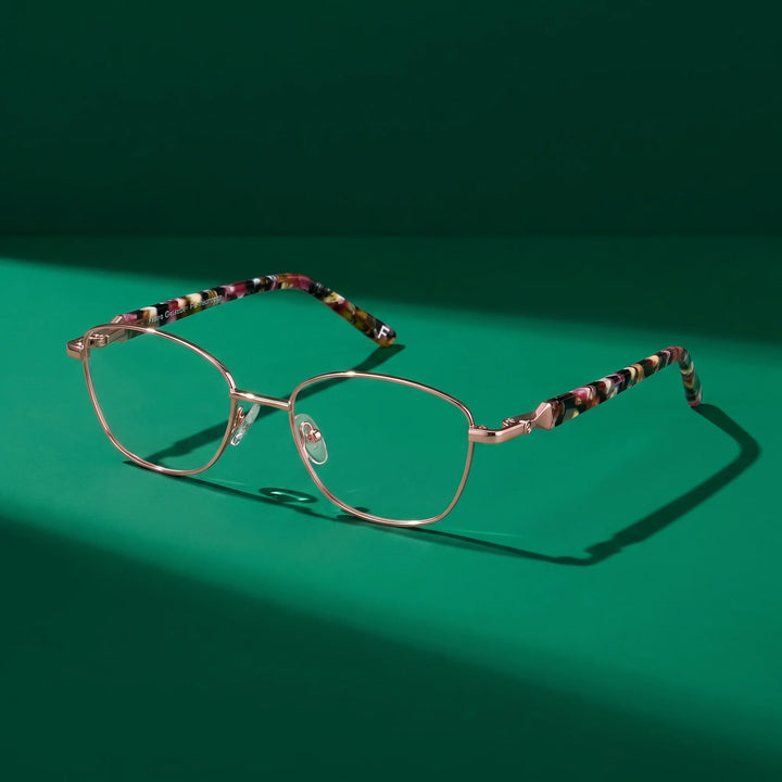 Anteojos Fiore 2208 en café dorado – still life on a seamless emerald studio backdrop