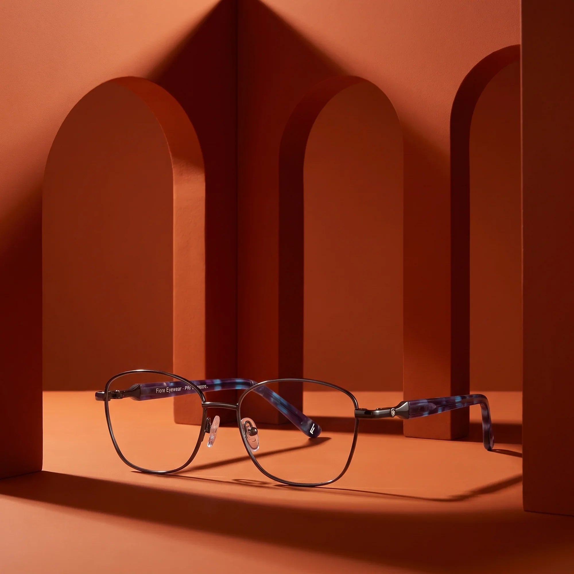 Anteojos Fiore 2208 en gun blue – still life among monochrome burnt orange arches