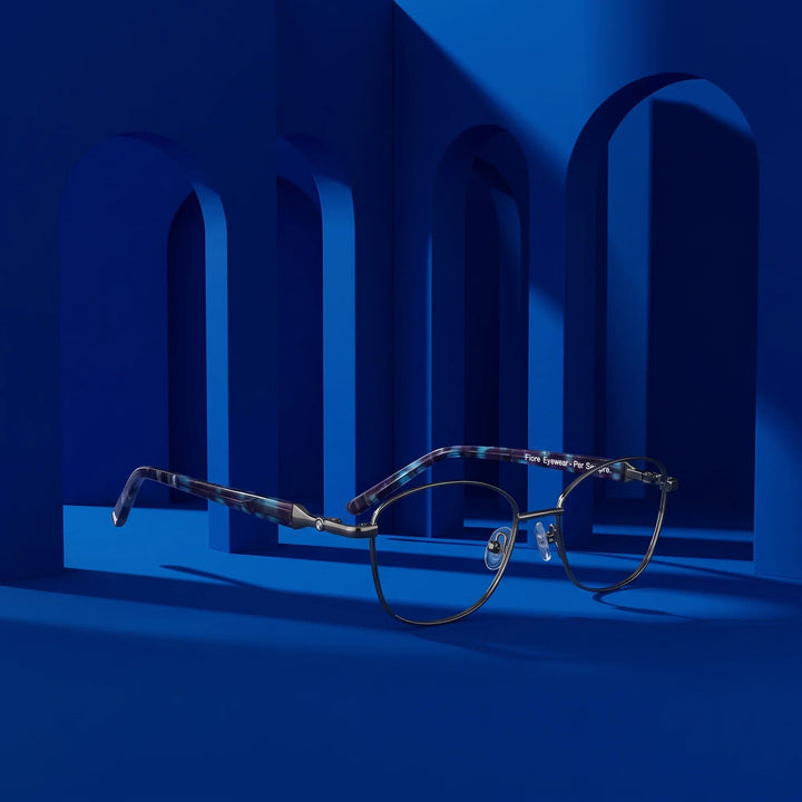 Anteojos Fiore 2208 en gunmetal azul – displayed on a cobalt podium among arches