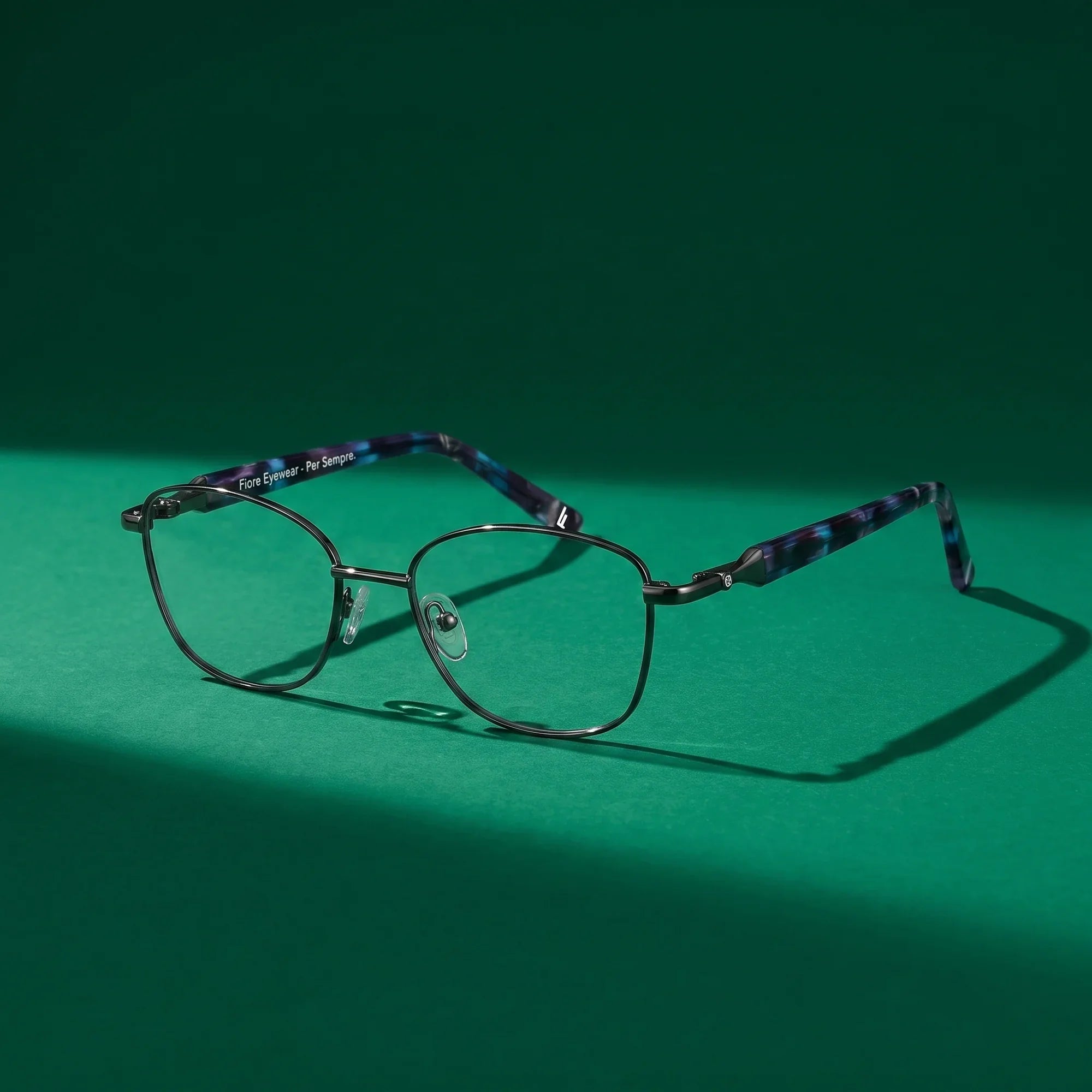Anteojos Fiore 2208 en gun blue – still life on a seamless emerald studio backdrop