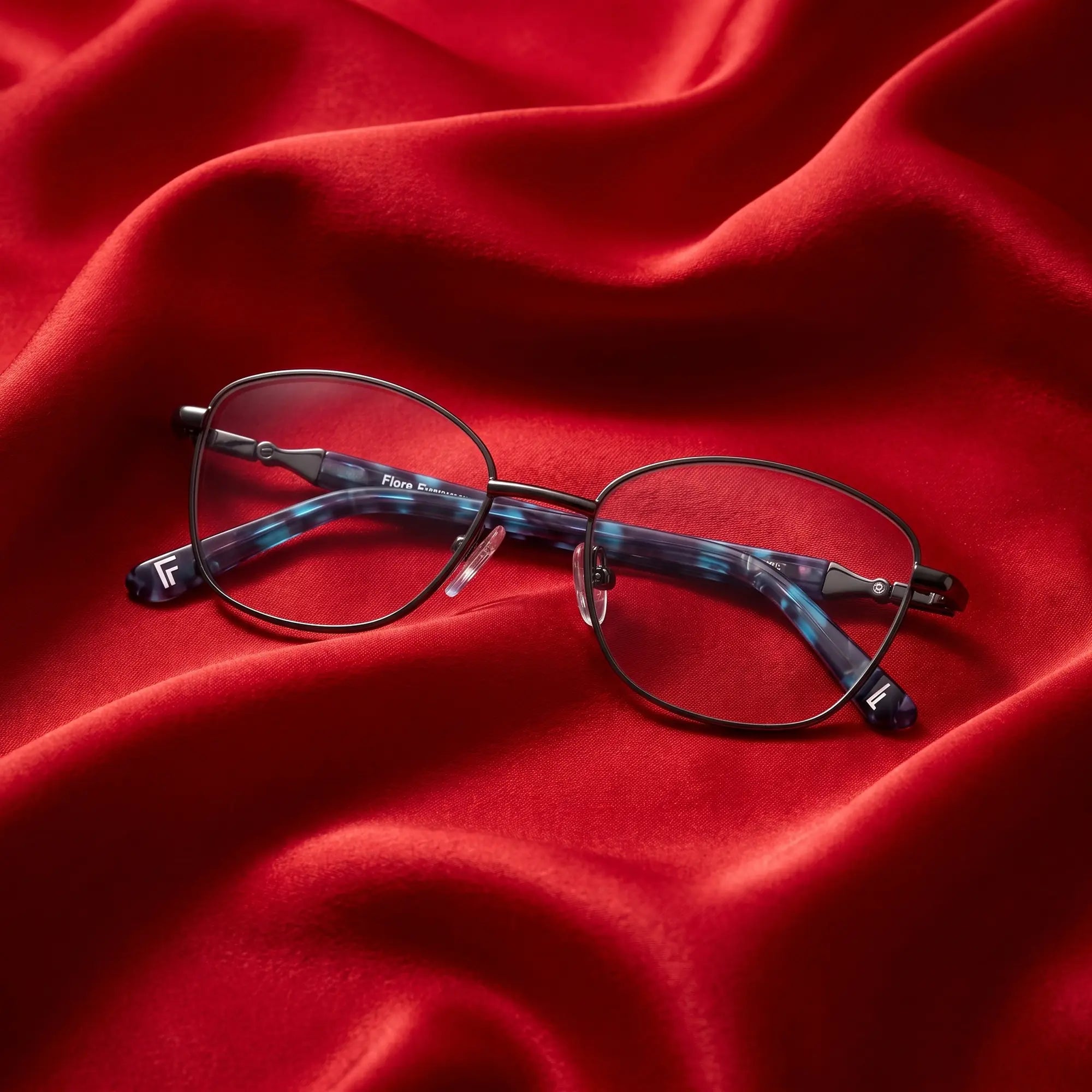 Anteojos Fiore 2208 en gun blue – nested in flowing vivid red silk