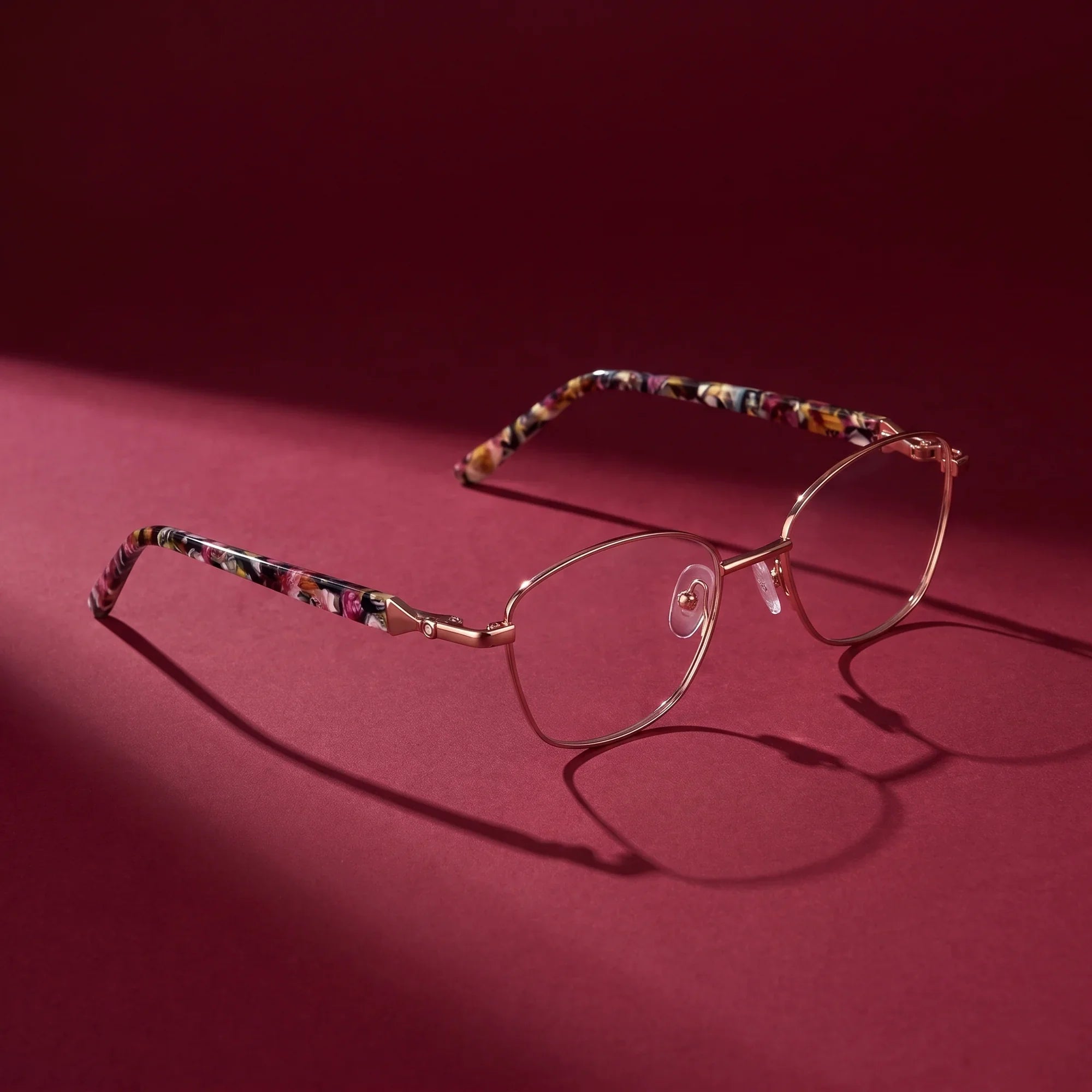 Anteojos Fiore 2208 en brown tortoiseshell – editorial still life on a saturated burgundy set