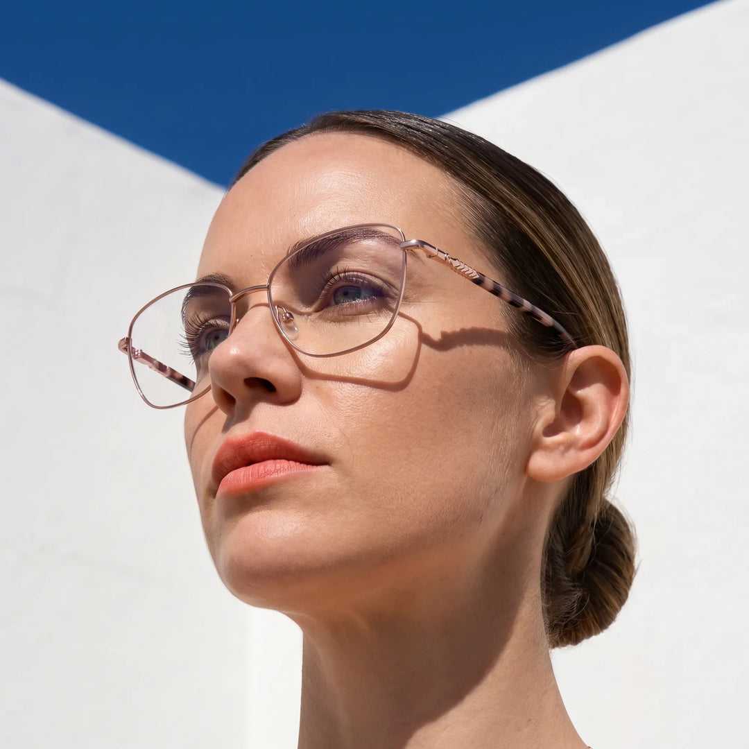 Anteojos Fiore 2210 en rosa, en modelo – retrato de campaña, cal balear al sol y cielo azul profundo