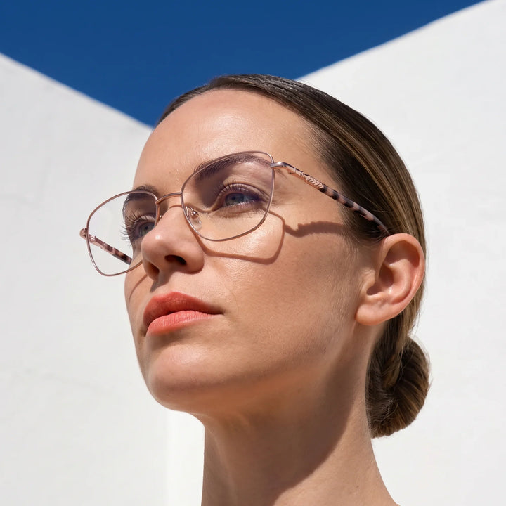 Anteojos Fiore 2210 en rosa, en modelo – retrato de campaña, cal balear al sol y cielo azul profundo