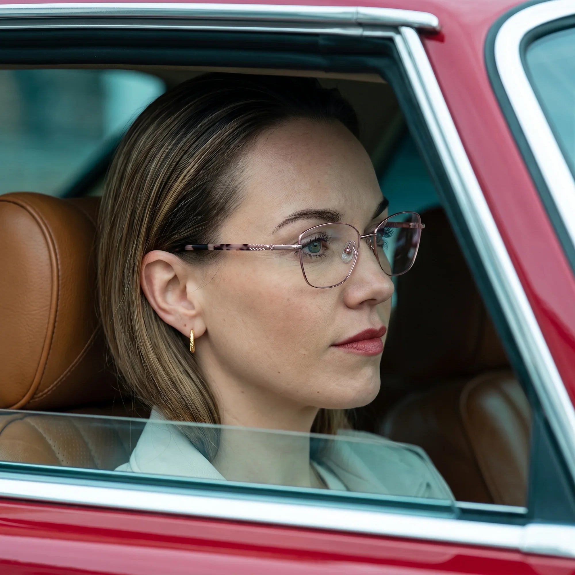 Anteojos Fiore 2210 en rosa, en modelo – retrato de campaña, mirada a través de la ventana de un auto clásico rojo