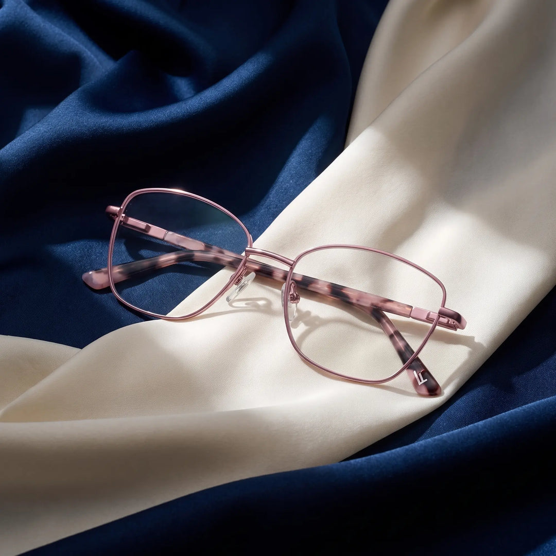 Anteojos Fiore 2210 en rosa – resting on draped midnight blue and ivory silk