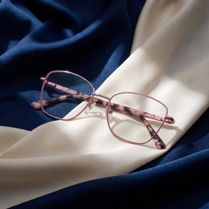 Anteojos Fiore 2210 en rosa – resting on draped midnight blue and ivory silk