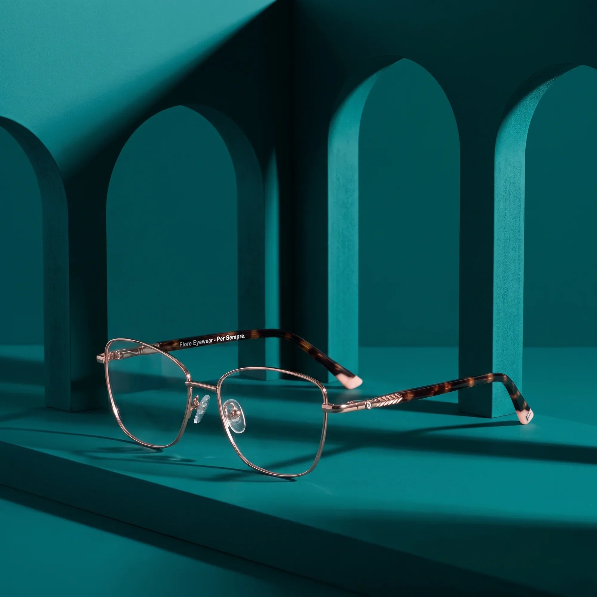 Anteojos Fiore 2210 en gold pink – still life among monochrome teal arches