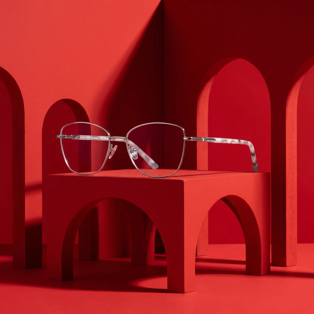 Anteojos Fiore 2210 en silver black – staged on a sculptural vivid red architecture set
