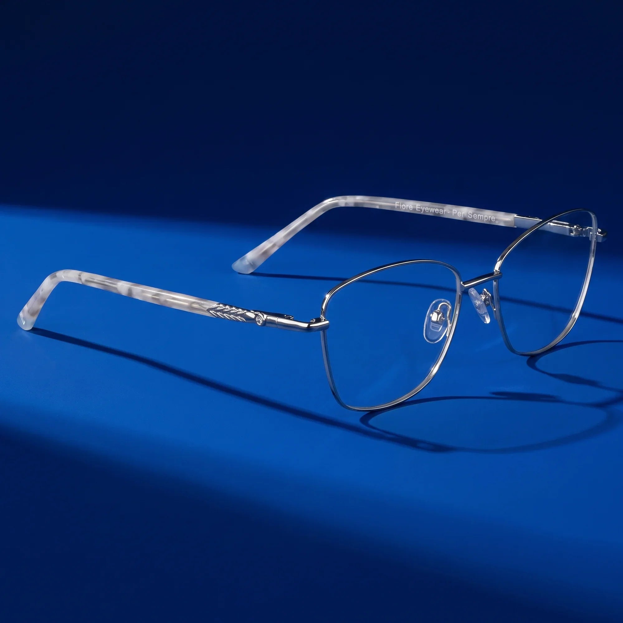 Anteojos Fiore 2210 en silver black – hero still life against a deep cobalt backdrop