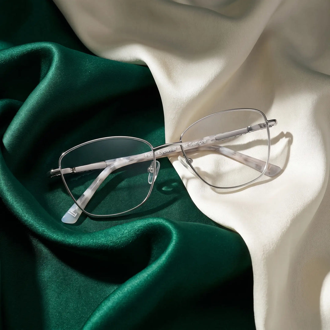Anteojos Fiore 2210 en silver black – resting on draped emerald and ivory silk