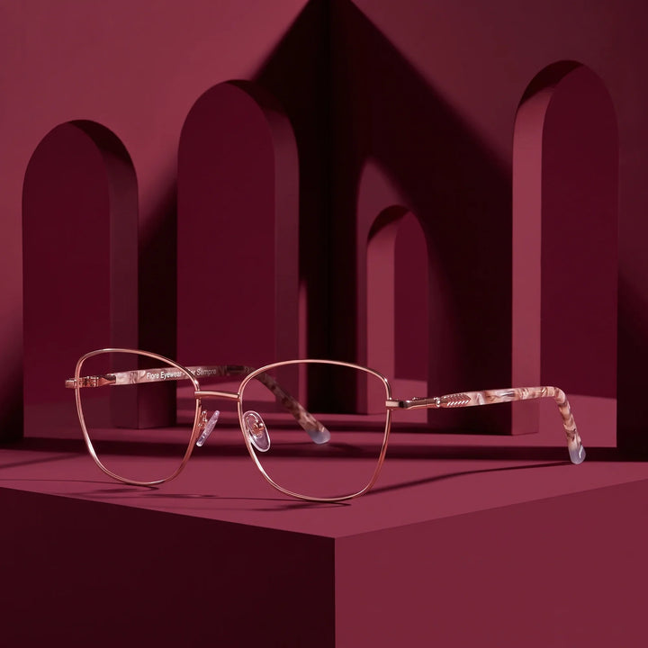 Anteojos Fiore 2210 en gold brown – displayed on a burgundy podium among arches