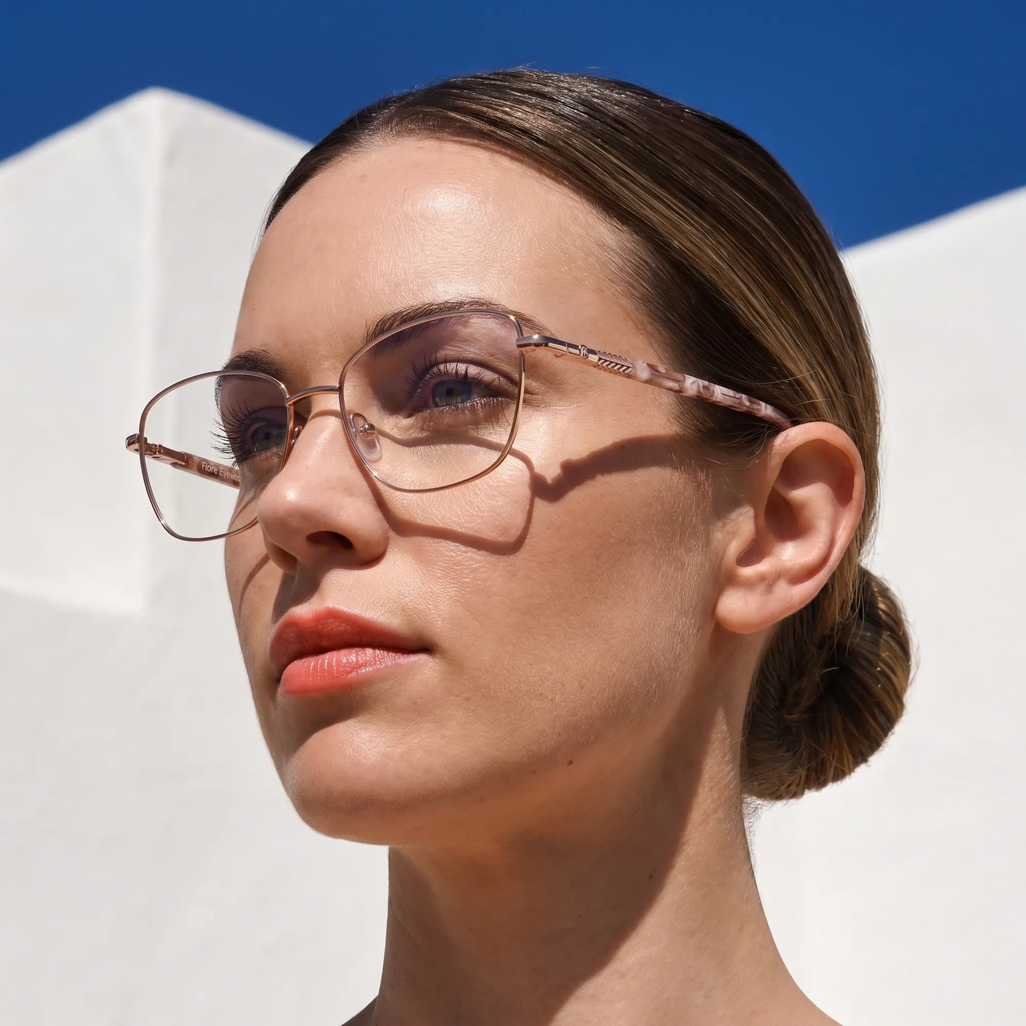 Anteojos Fiore 2210 en gold brown, en modelo – retrato de campaña, cal balear al sol y cielo azul profundo