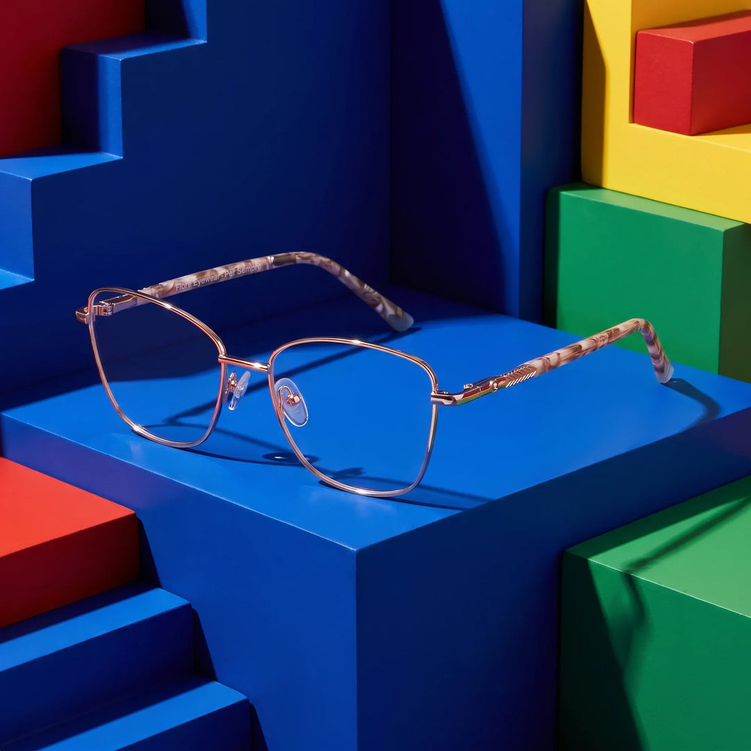 Anteojos Fiore 2210 en dorado café – sobre gradas de bloques de colores primarios