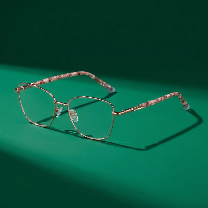 Anteojos Fiore 2210 en gold brown – bodegón editorial sobre un set esmeralda saturado