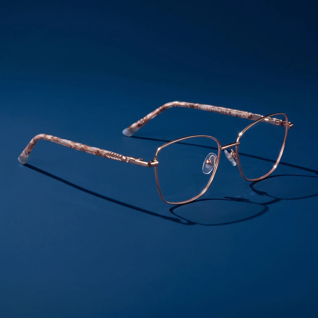 Anteojos Fiore 2210 en dorado café – hero still life against a deep midnight blue backdrop