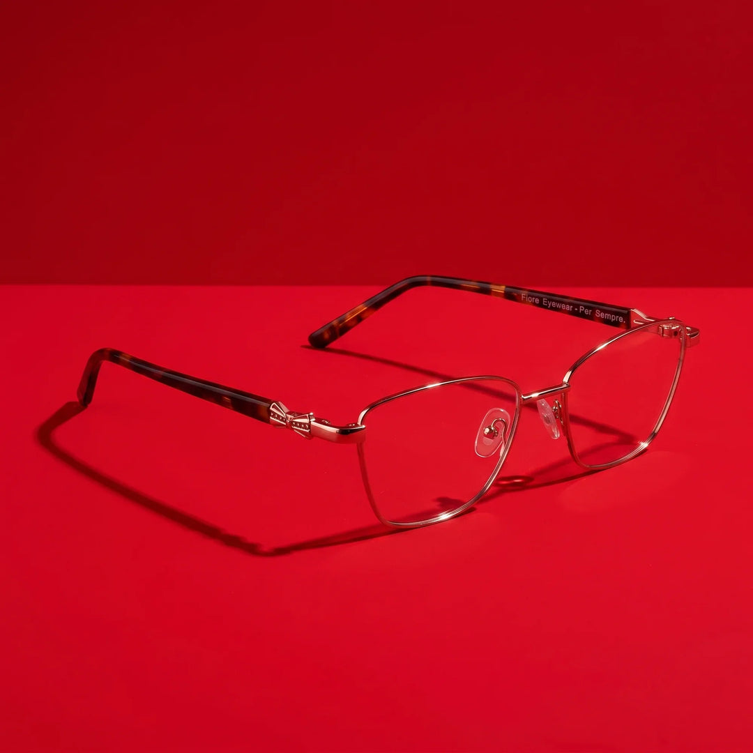 Anteojos Fiore 22115 en café – hero still life against a deep vivid red backdrop