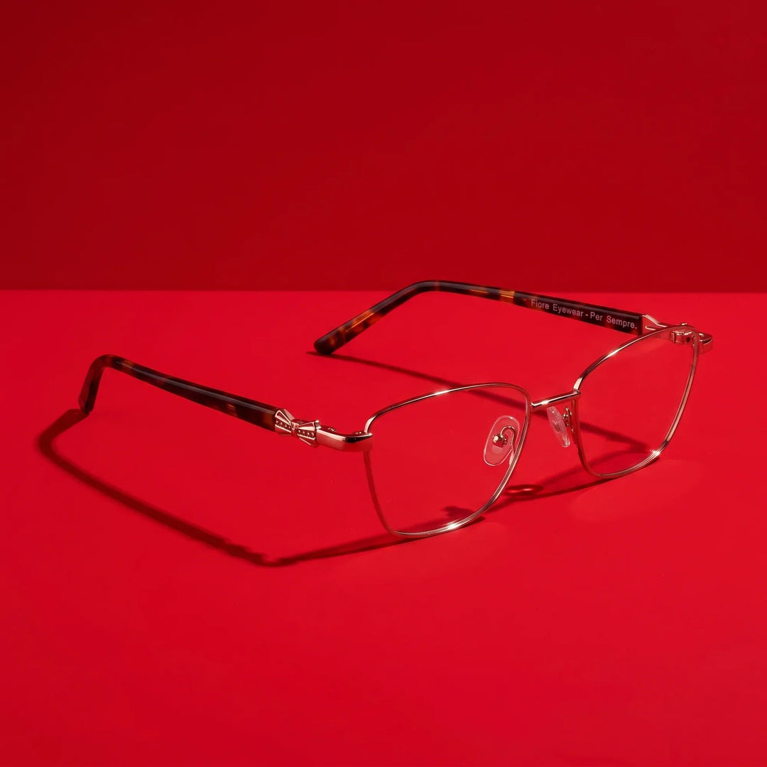 Anteojos Fiore 22115 en café – hero still life against a deep vivid red backdrop