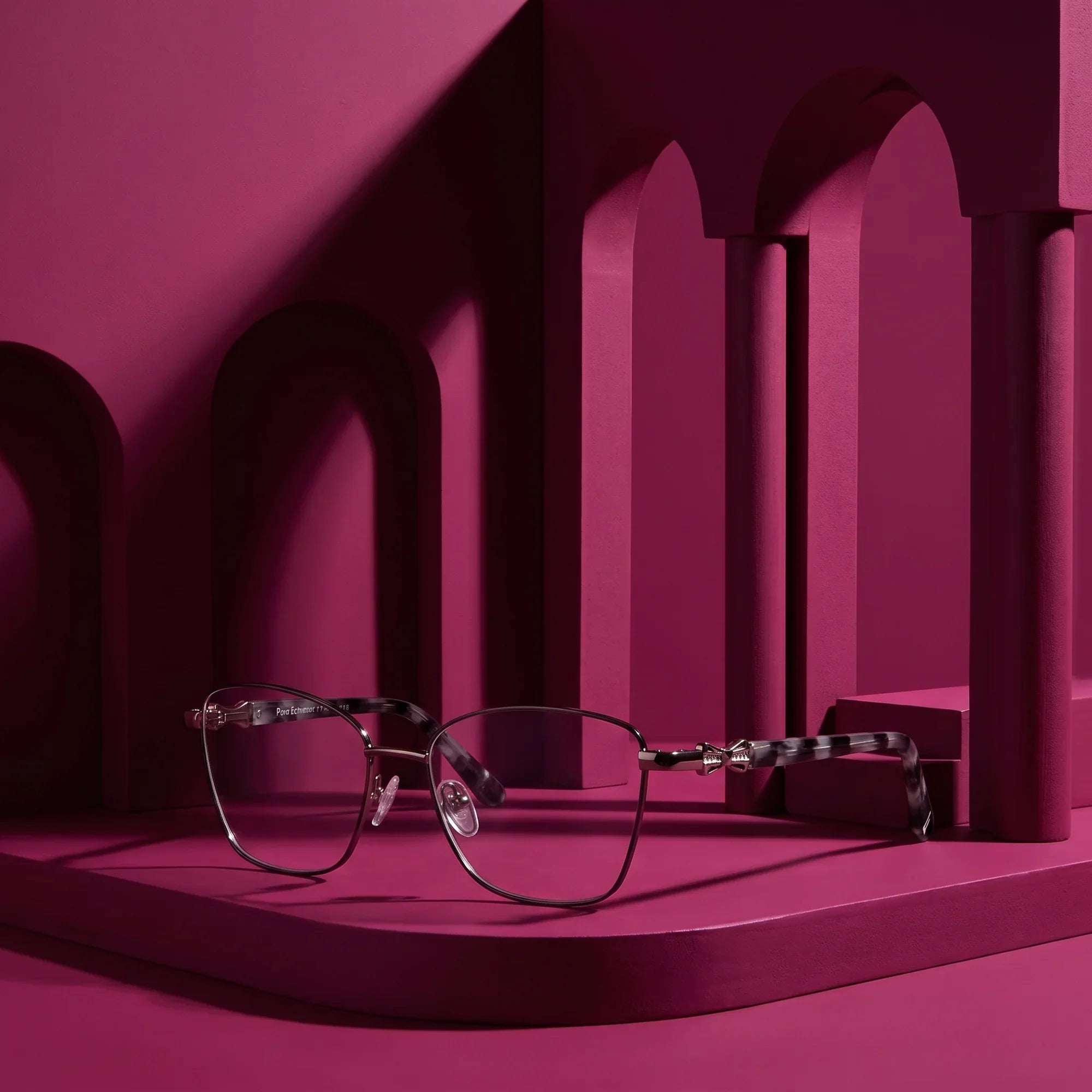 Anteojos Fiore 22115 en black silver – staged on a sculptural magenta architecture set