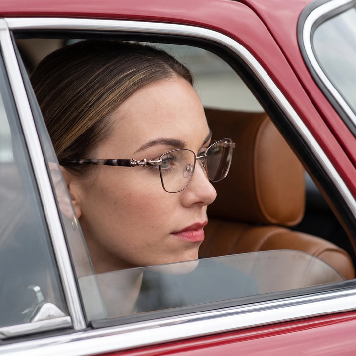 Anteojos Fiore 22115 en black silver, en modelo – retrato de campaña, mirada a través de la ventana de un auto clásico rojo