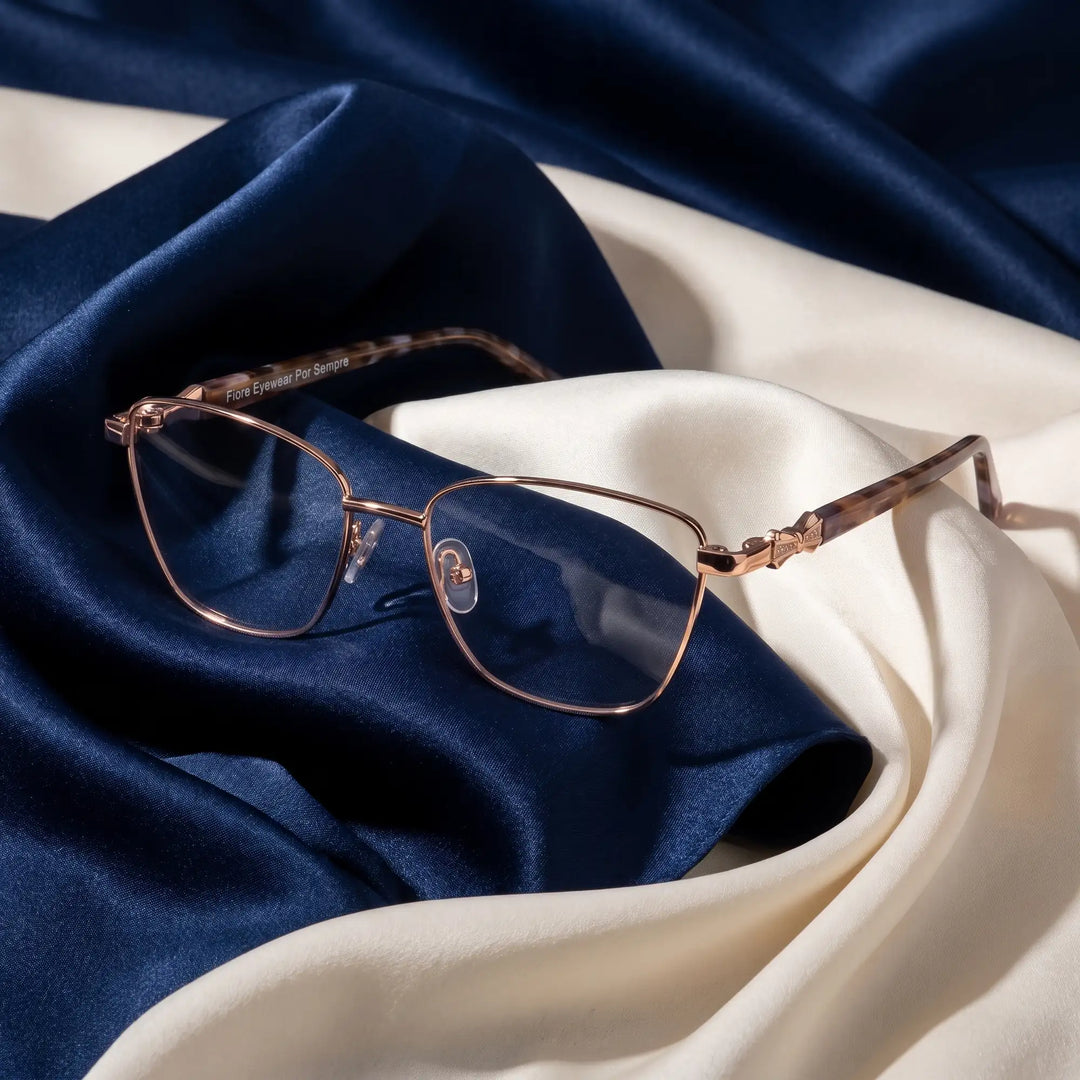 Anteojos Fiore 22115 en gold – resting on draped midnight blue and ivory silk