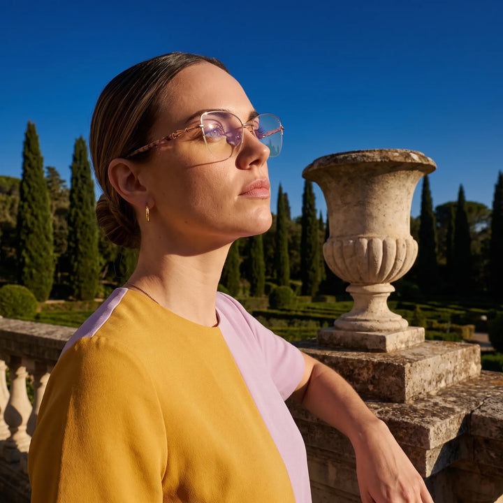 Anteojos Fiore 22117 en gold, en modelo – retrato de campaña, luz de atardecer sobre un jardín de cipreses