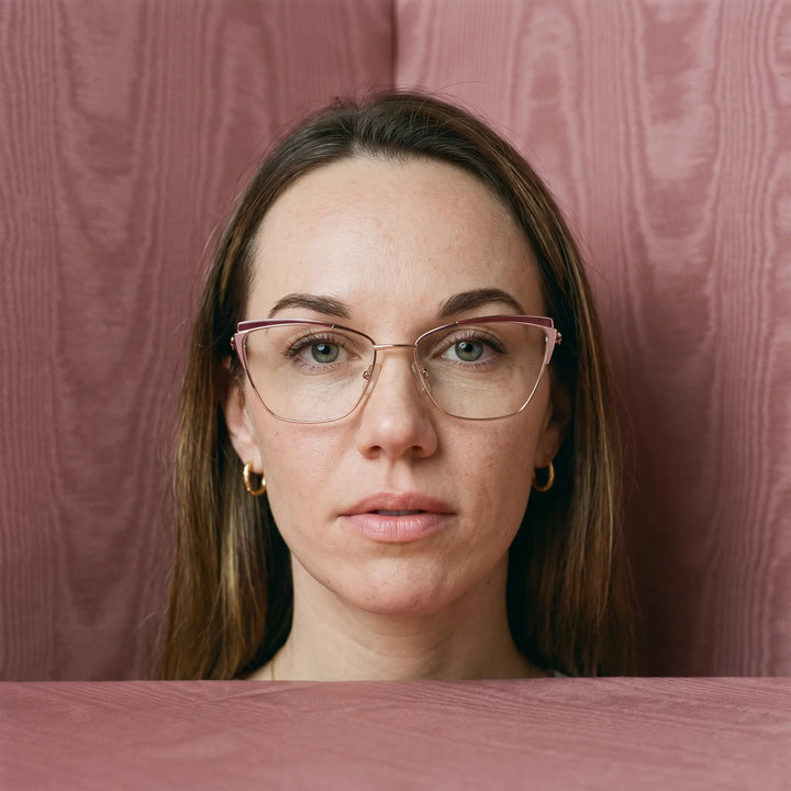 Anteojos Fiore 3837 en red gold, en modelo – retrato de campaña, face framed by rose moire upholstery