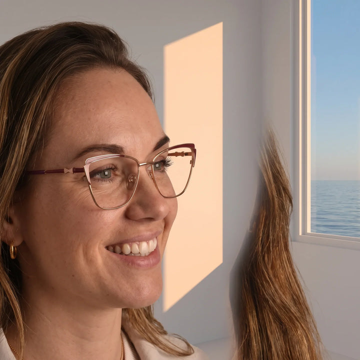 Anteojos Fiore 3837 en red gold, en modelo – retrato de campaña, smiling at a bright window over the sea