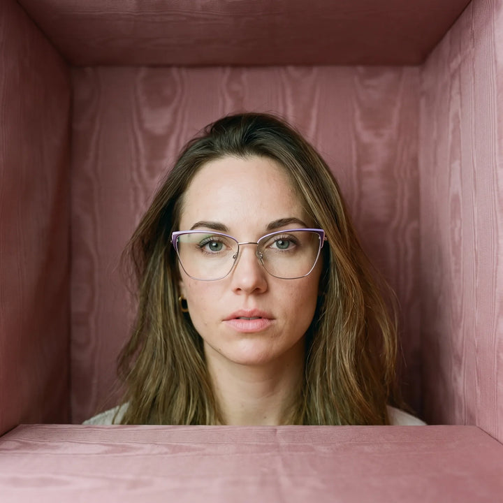 Anteojos Fiore 3839 en purple silver, en modelo – retrato de campaña, face framed by rose moire upholstery
