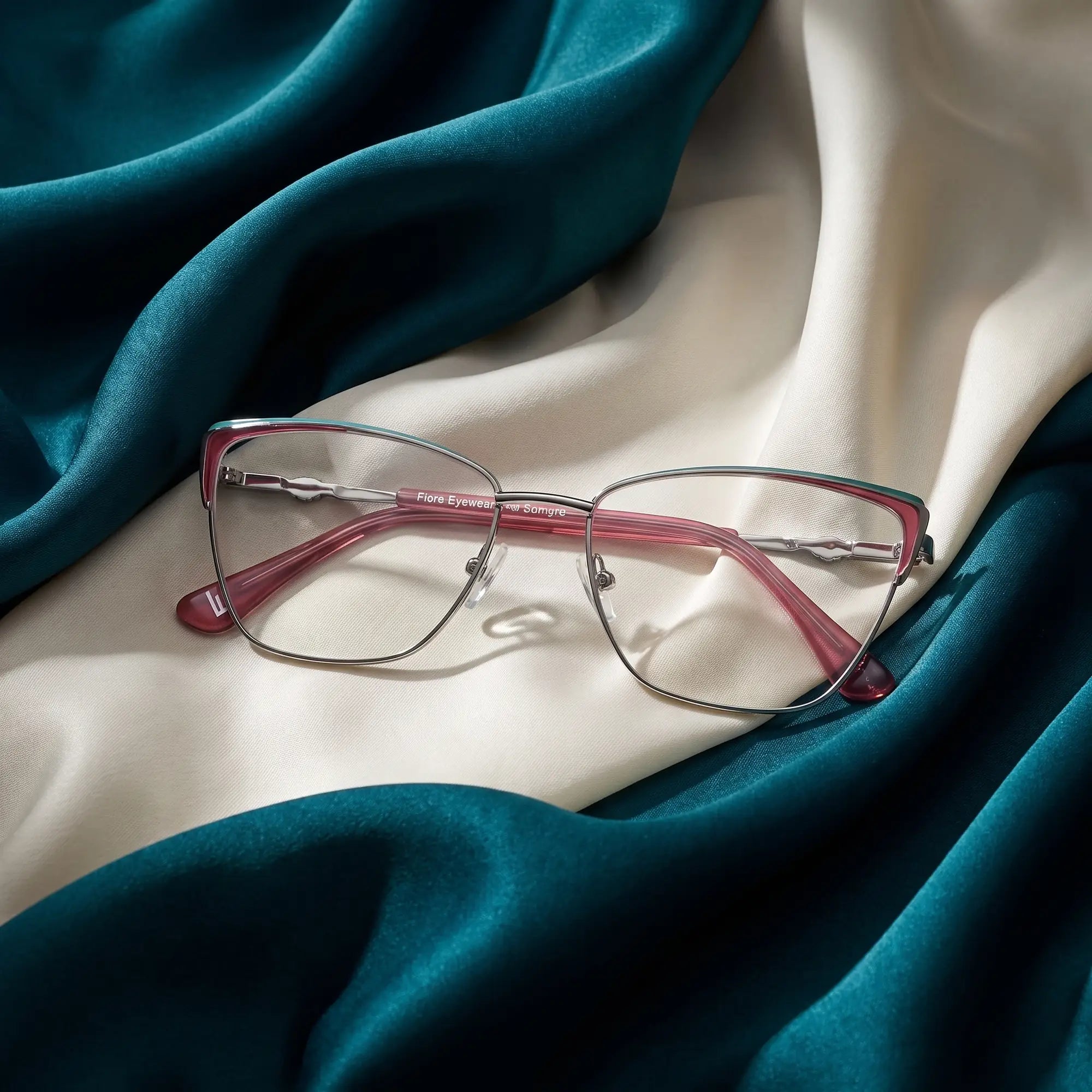 Anteojos Fiore 3839 en red gun – resting on draped teal and ivory silk