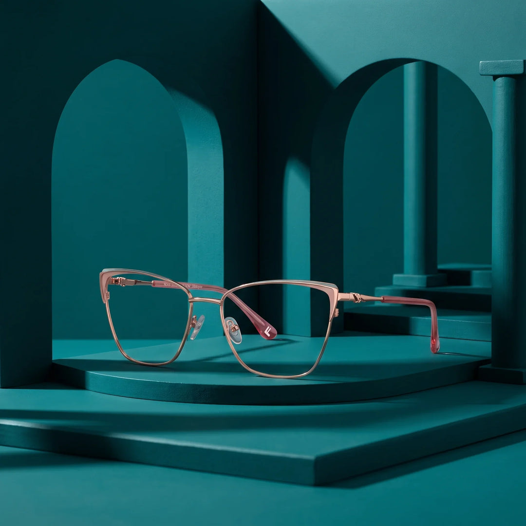 Anteojos Fiore 3839 en pink gold – displayed on a teal podium among arches