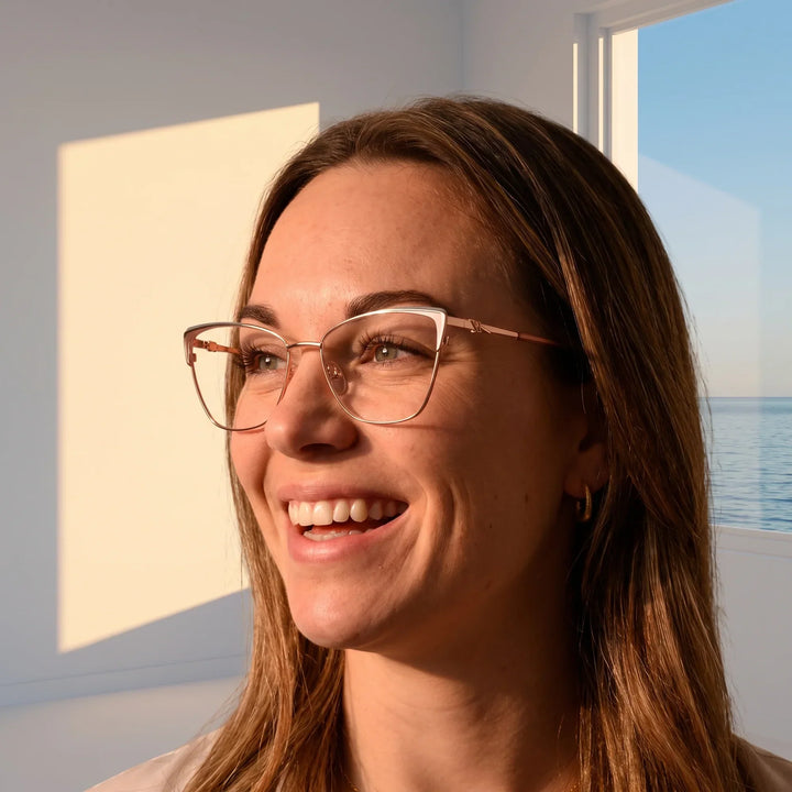 Anteojos Fiore 3839 en rosado dorado, en modelo – retrato de campaña, smiling at a bright window over the sea