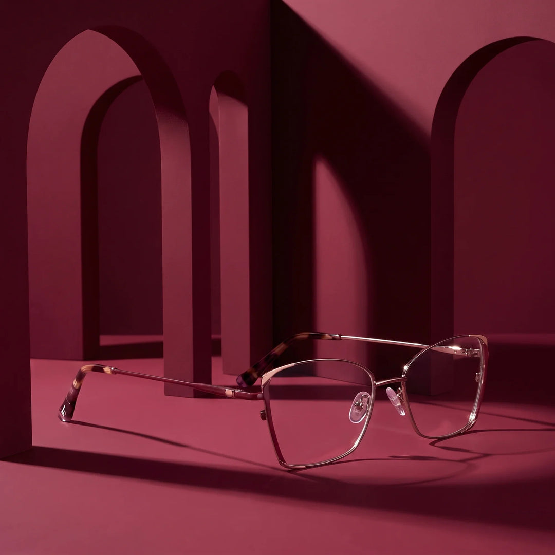 Anteojos Fiore 3916 en purple pink silver – displayed on a burgundy podium among arches