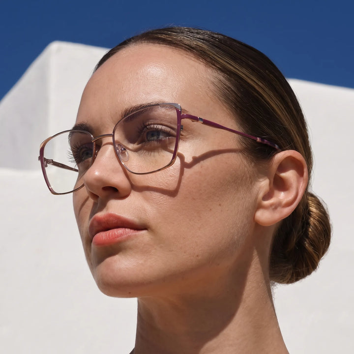 Anteojos Fiore 3916 en purple pink silver, en modelo – retrato de campaña, cal balear al sol y cielo azul profundo