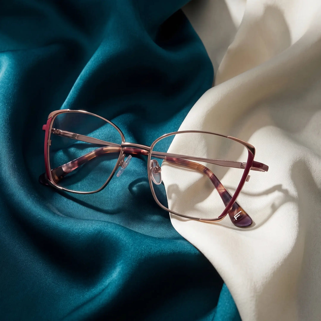 Anteojos Fiore 3916 en purple pink silver – resting on draped teal and ivory silk
