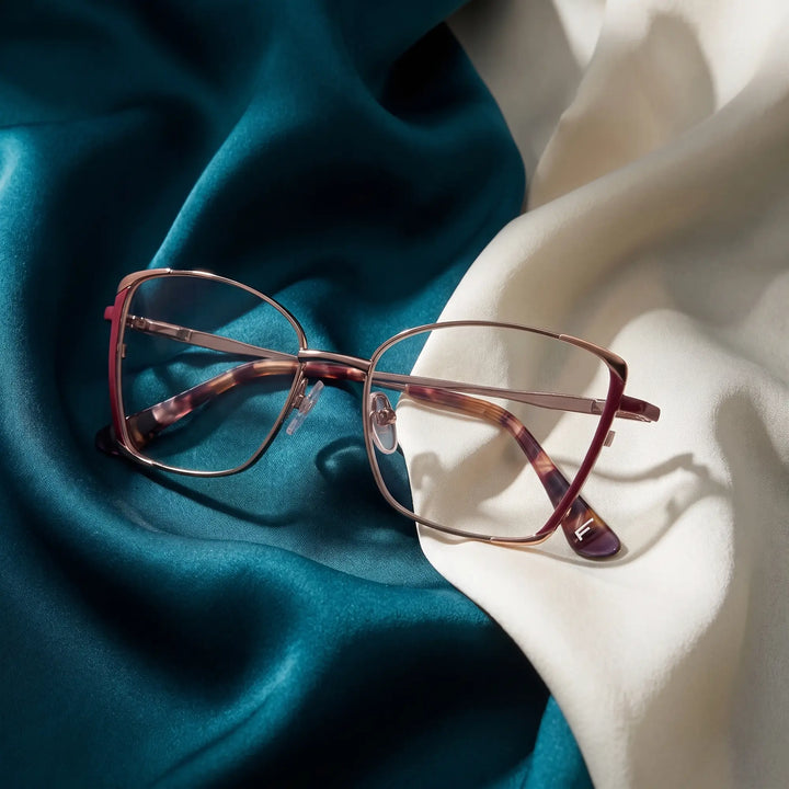 Anteojos Fiore 3916 en purple pink silver – resting on draped teal and ivory silk