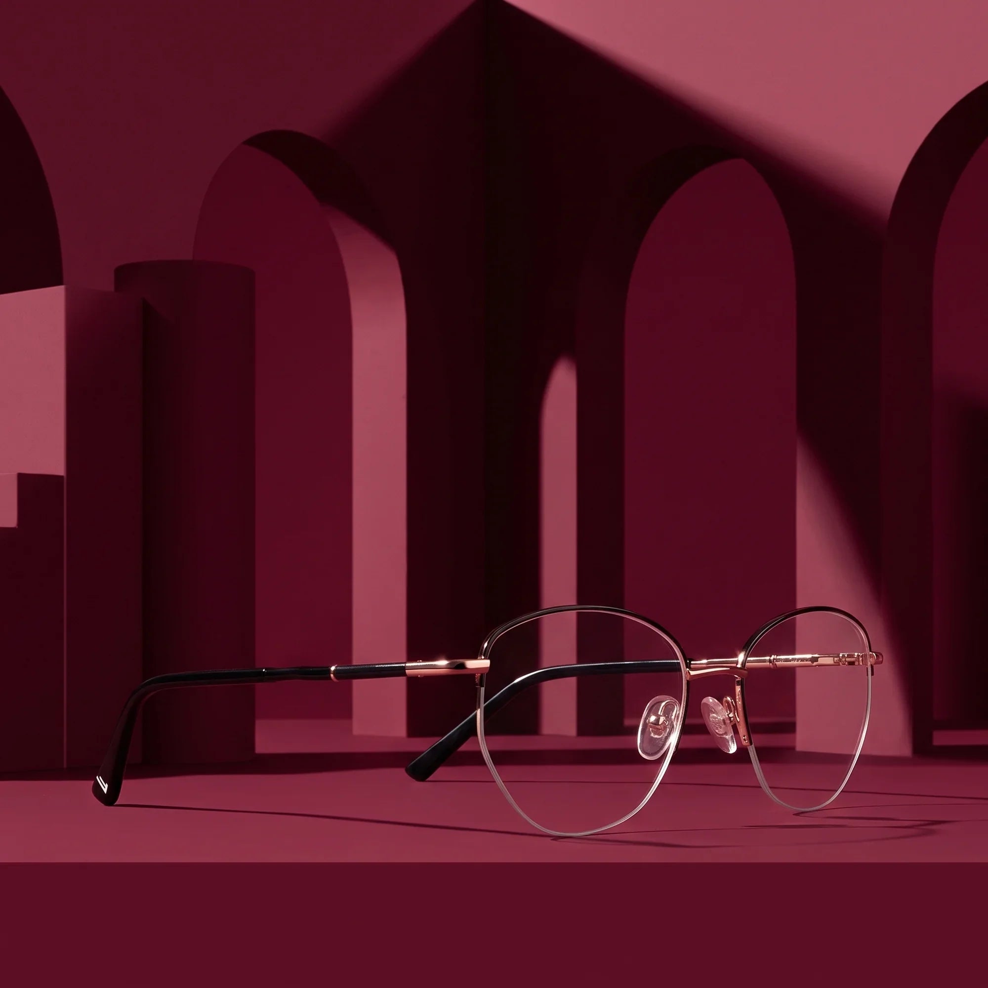 Anteojos Fiore 3921 en black gold – displayed on a burgundy podium among arches