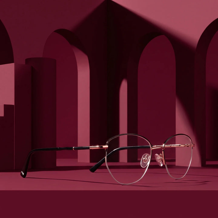 Anteojos Fiore 3921 en black gold – displayed on a burgundy podium among arches