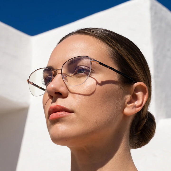 Anteojos Fiore 3921 en black gold, en modelo – retrato de campaña, cal balear al sol y cielo azul profundo
