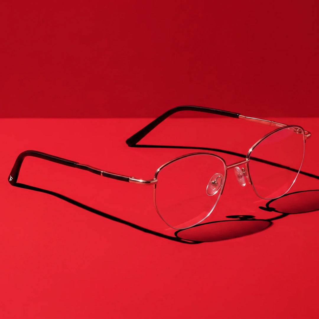 Anteojos Fiore 3921 en negro dorado – editorial still life on a saturated vivid red set
