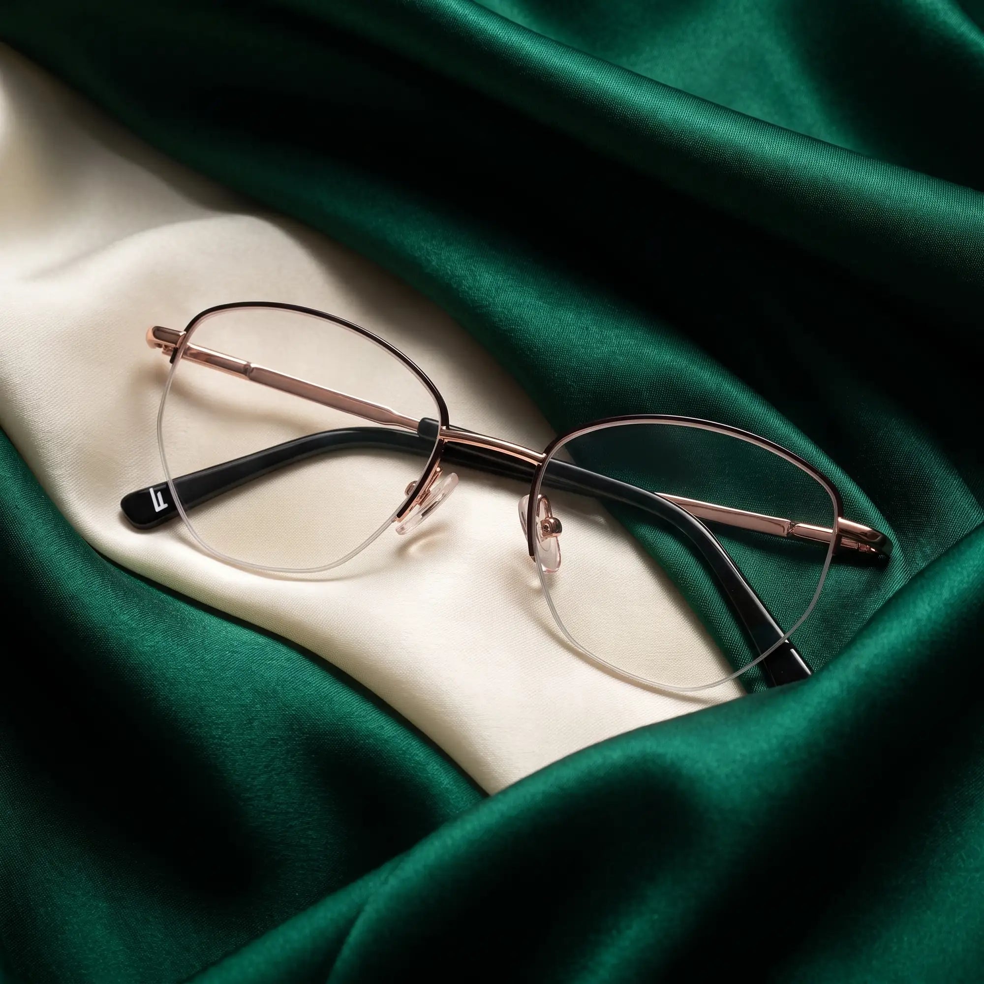 Anteojos Fiore 3921 en black gold – resting on draped emerald and ivory silk