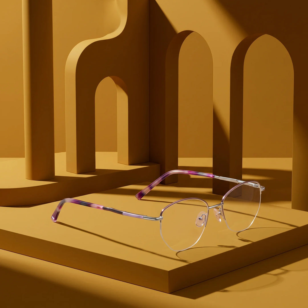 Anteojos Fiore 3921 en morado plateado – displayed on a mustard ochre podium among arches