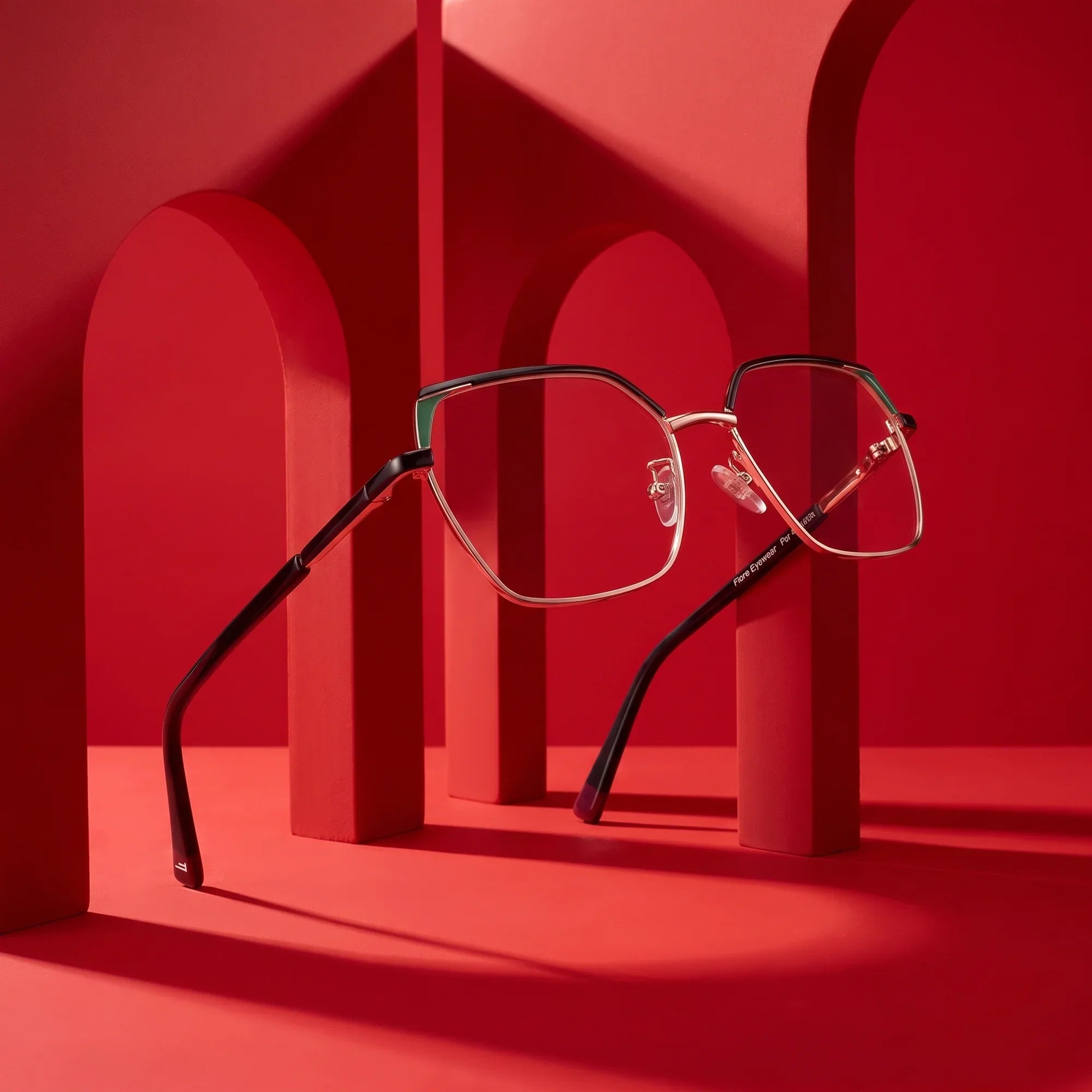 Anteojos Fiore 3971 en black gold – displayed on a vivid red podium among arches