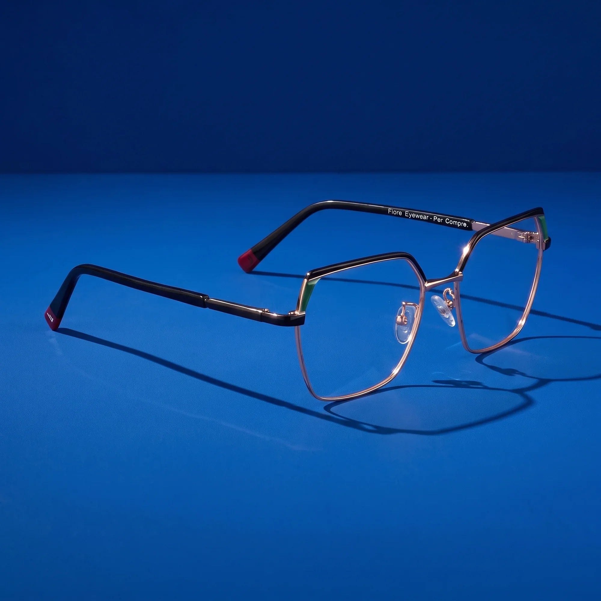 Anteojos Fiore 3971 en black gold – editorial still life on a saturated cobalt set