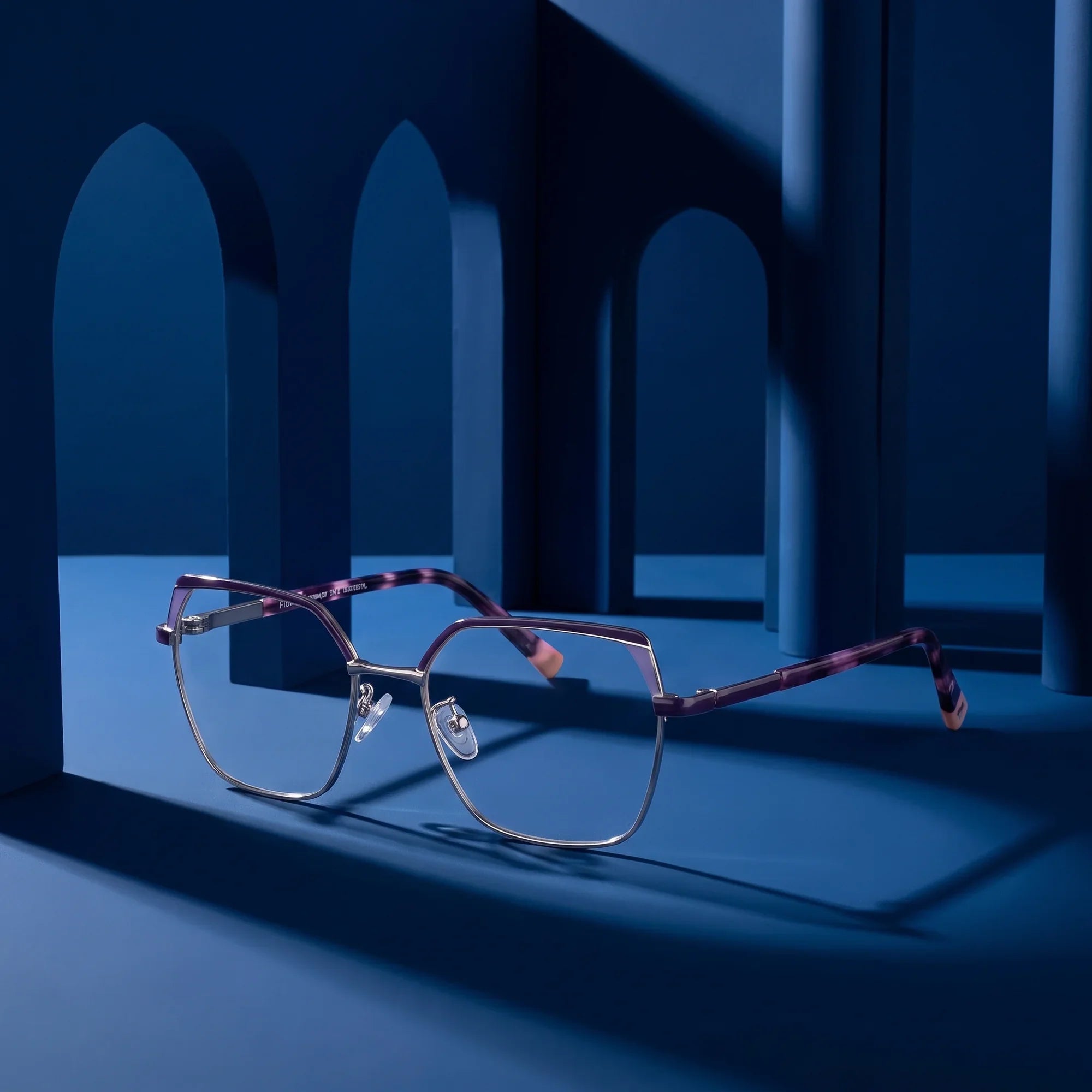 Anteojos Fiore 3971 en purple silver – staged on a sculptural midnight blue architecture set