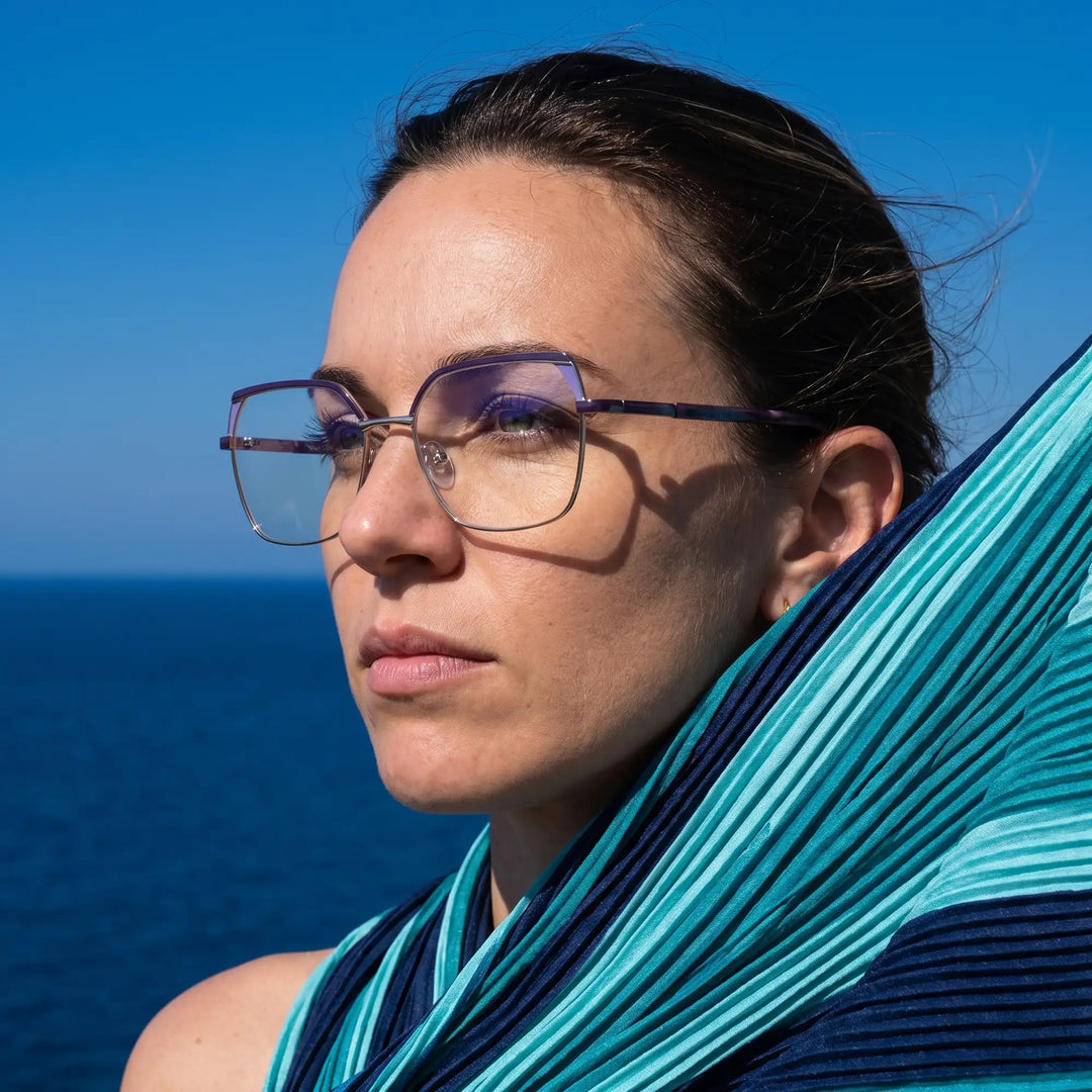 Anteojos Fiore 3971 en purple silver, en modelo – retrato de campaña, retrato al viento sobre el mar azul profundo