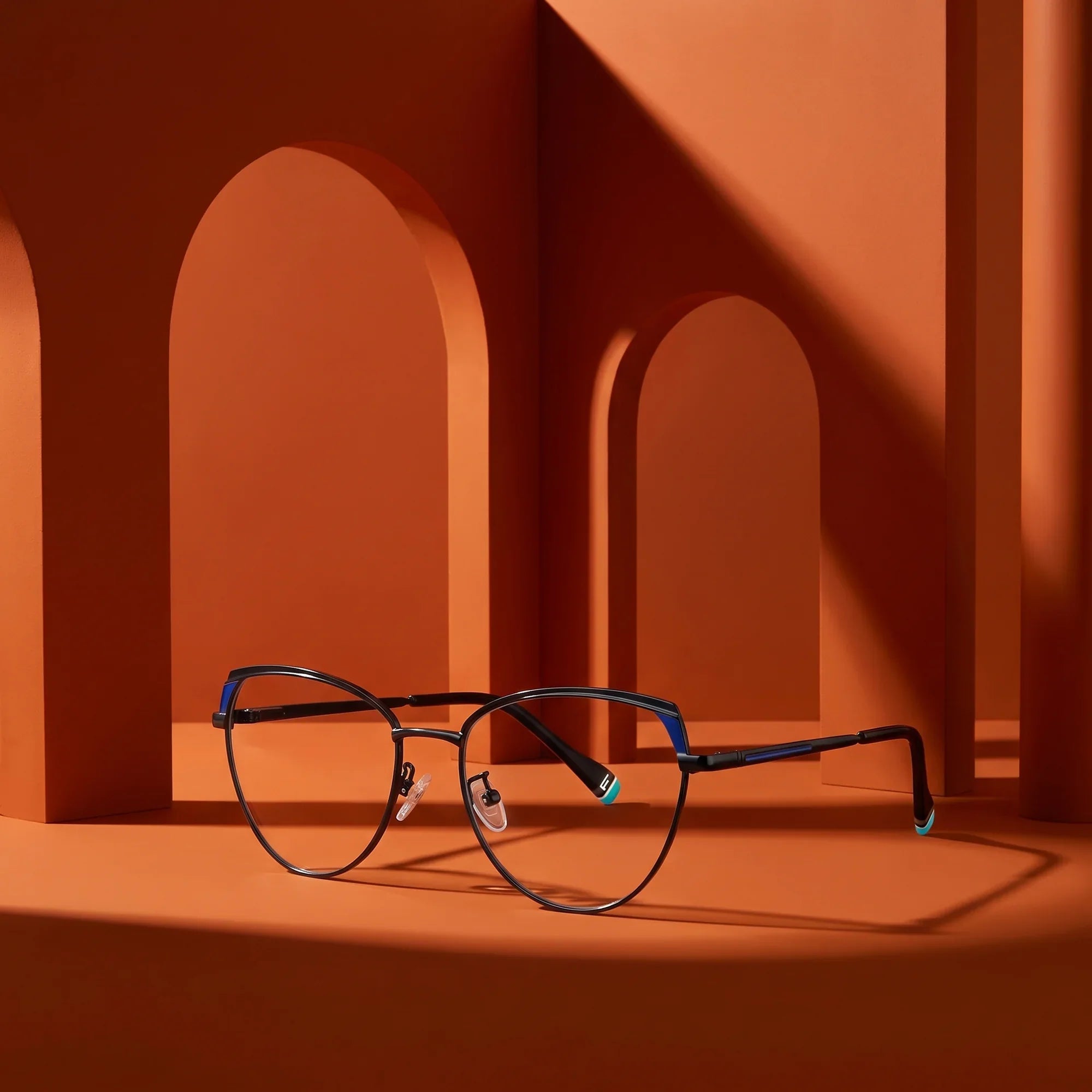 Anteojos Fiore 3983 en black blue – staged on a sculptural burnt orange architecture set