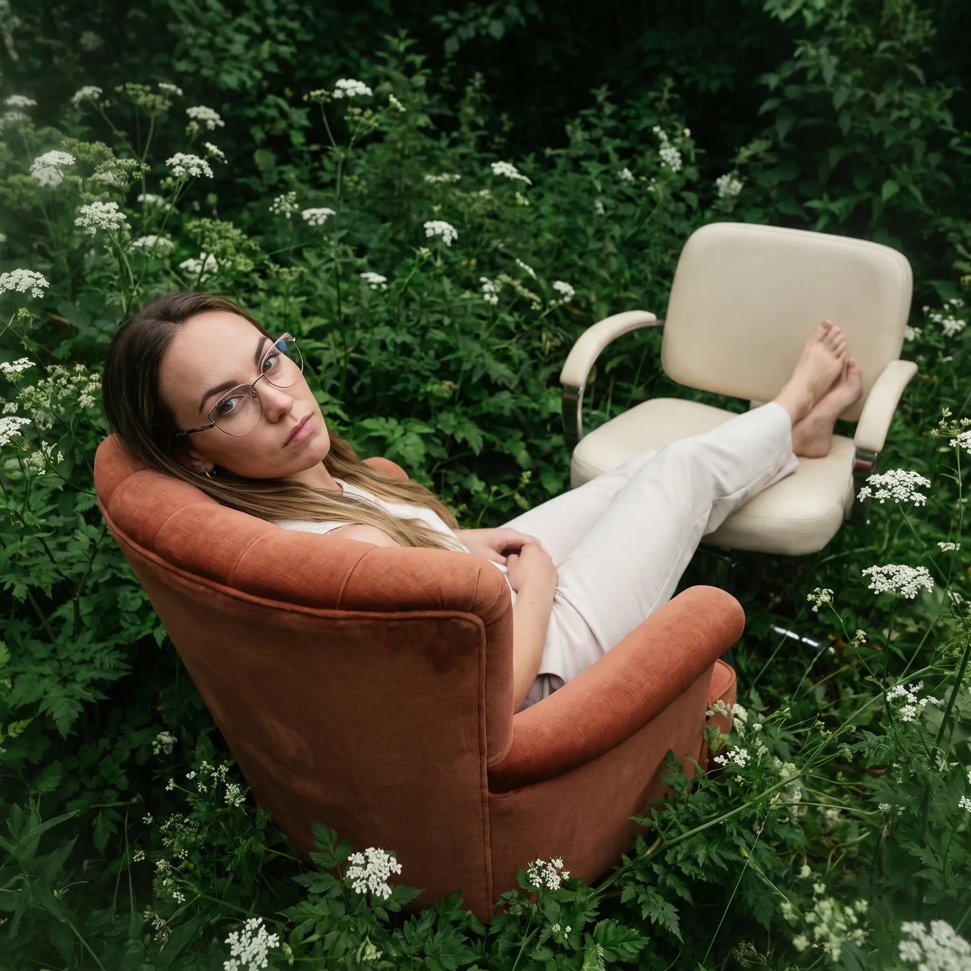 Anteojos Fiore 3983 en grey gun, en modelo – retrato de campaña, lounging in an armchair in a wildflower meadow