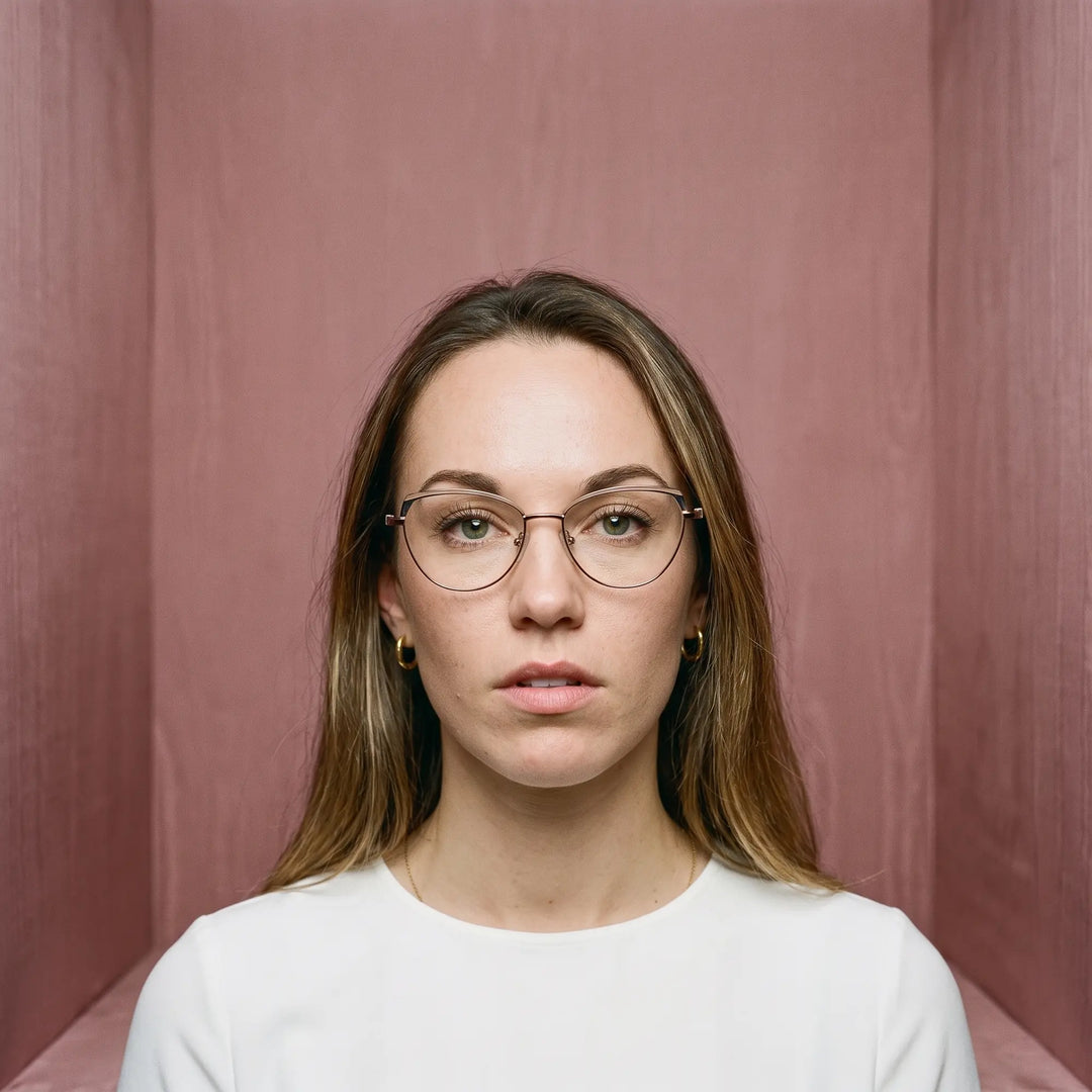 Anteojos Fiore 3983 en grey gun, en modelo – retrato de campaña, face framed by rose moire upholstery